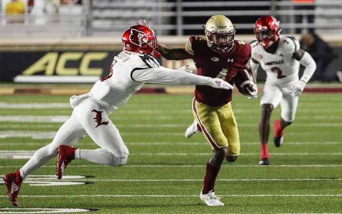 Nov 28, 2020; Chestnut Hill, Massachusetts, USA; Boston College Eagles wide receiver Zay Flowers (4) stiff arms Louisville Cardinals defensive back Russ Yeast (3) during the first half at Alumni Stadium.